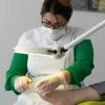A specialist performing a detailed pedicure procedure in an indoor salon setting.